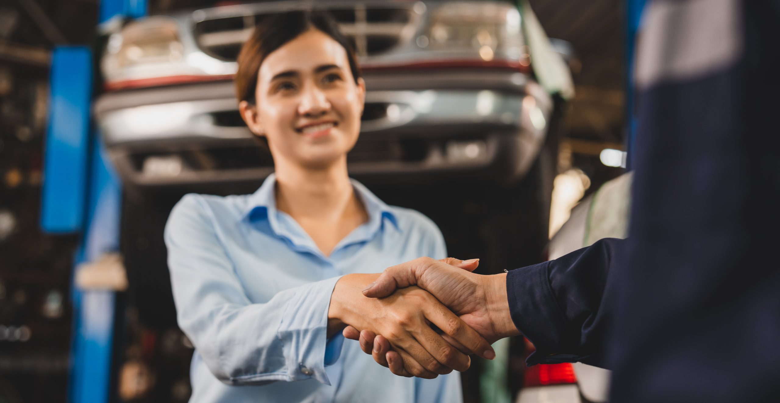 mechanic technician making handshake deal with business customer at auto car garage service